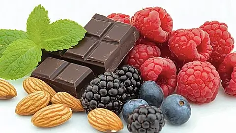 Antioxidant-rich foods including various berries, nuts, and dark chocolate